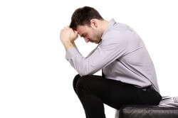 Business man sat in despair isolated on a white background