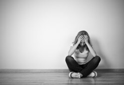 Girl Sits In A Depression On The Floor Near The Wall